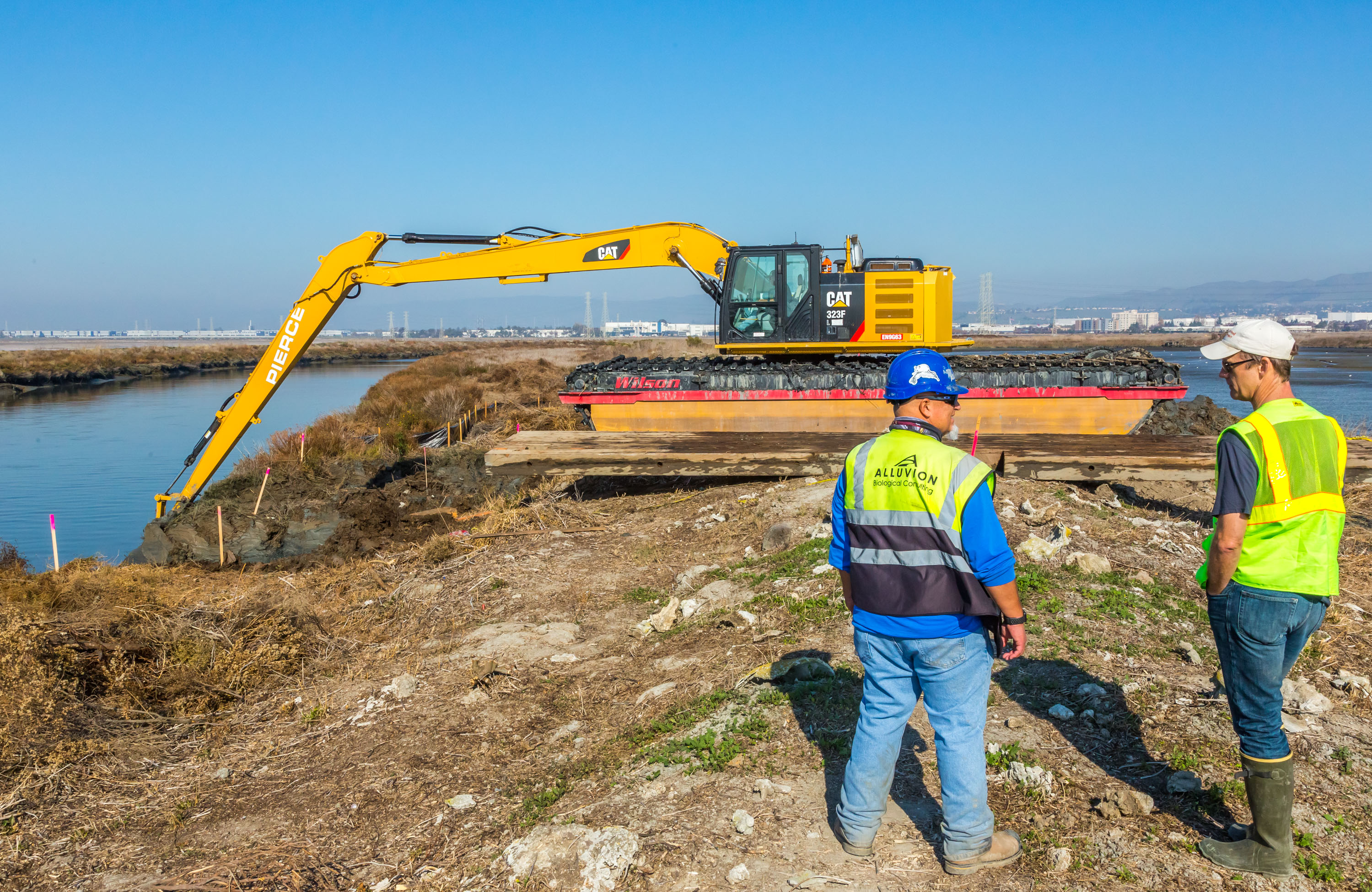 An excavator tears down a levee at Pond A19. Credit: Julie Kitzenberger