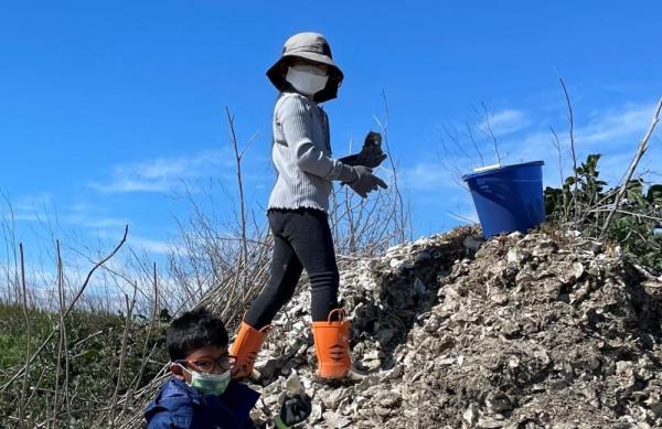 Two young 2022 volunteers on an oyster shell pile. Credit: Laura Cholodenko