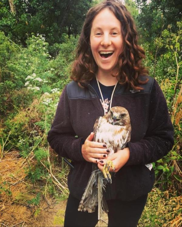 Maddy Schwarz with a red-tailed hawk in hand