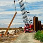 Workers and a crane putting in sheet pilings for a water control structure at Pond A16 to control water for shorebirds. Credit: Judy Irving, Pelican Media.