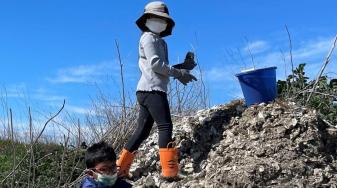 Two young 2022 volunteers on an oyster shell pile. Credit: Laura Cholodenko