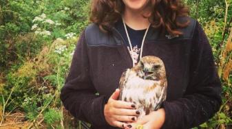 Maddy Schwarz with a red-tailed hawk in hand