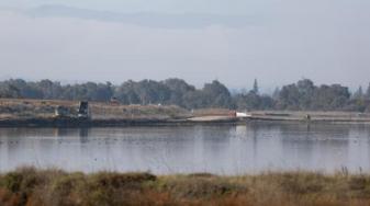 Pond A1 in December 2025 with trucks bringing dirt for construction. Credit: Magali Gauthier